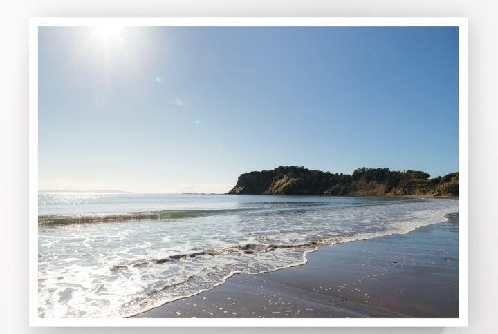 Small waves lap the shore at Army Bay Beach, Whangaparaoa